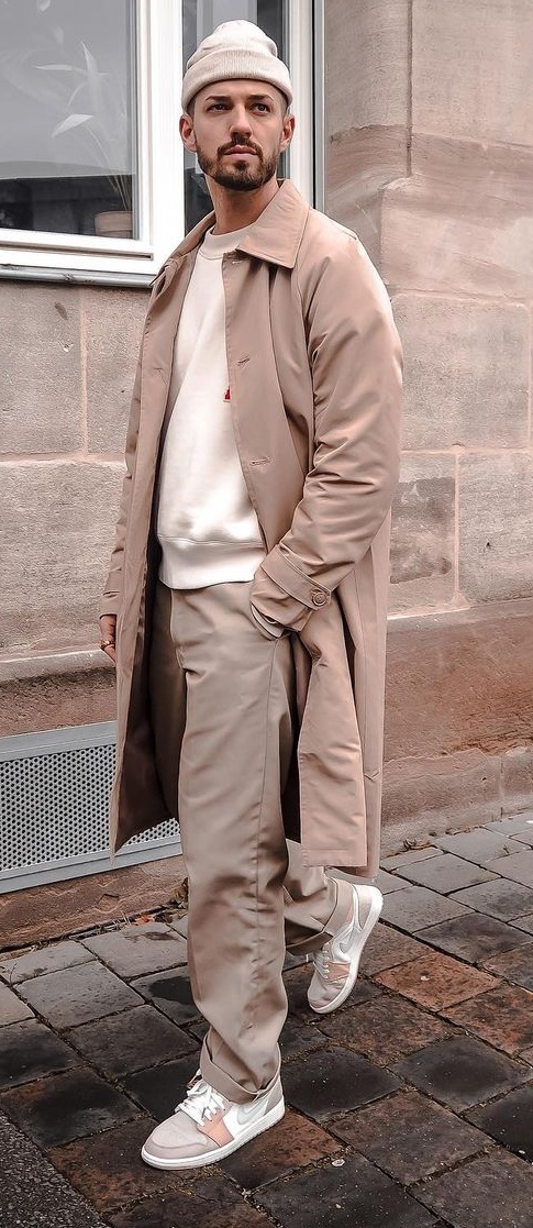 Neutral color tones for winter with a sweater layered with topcoat and styled with beanie and sneakers Neutral color tones for winter with a sweater layered with topcoat and styled with beanie and sneakers