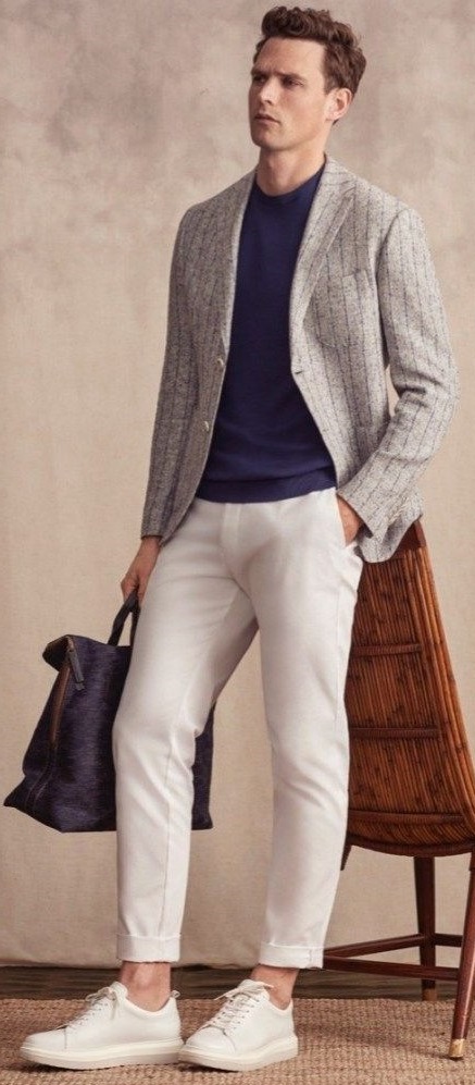 Grey suit with navy blue t-shirt and cream chinos and white shoes, holding a bag_ Grey suit with navy blue t-shirt and cream chinos and white shoes, holding a bag_