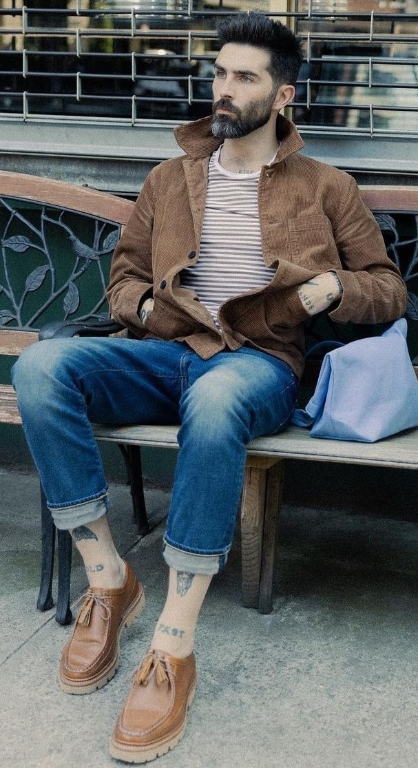 beige and white stripped t-shirt with brown jacket and blue denims with blue side bag beige and white stripped t-shirt with brown jacket and blue denims with blue side bag