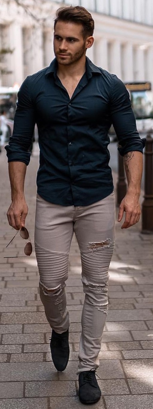 green shirt with beige pants, wearing a black shoe in bottom and shades in hands green shirt with beige pants, wearing a black shoe in bottom and shades in hands