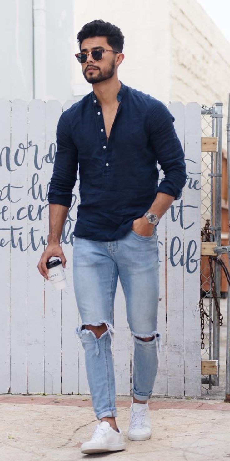 ripped denims with blue half buttoned t-shirt, rolled up sleeves accessorized with watch and shades and white sneakers_ ripped denims with blue half buttoned t-shirt, rolled up sleeves accessorized with watch and shades and white sneakers_