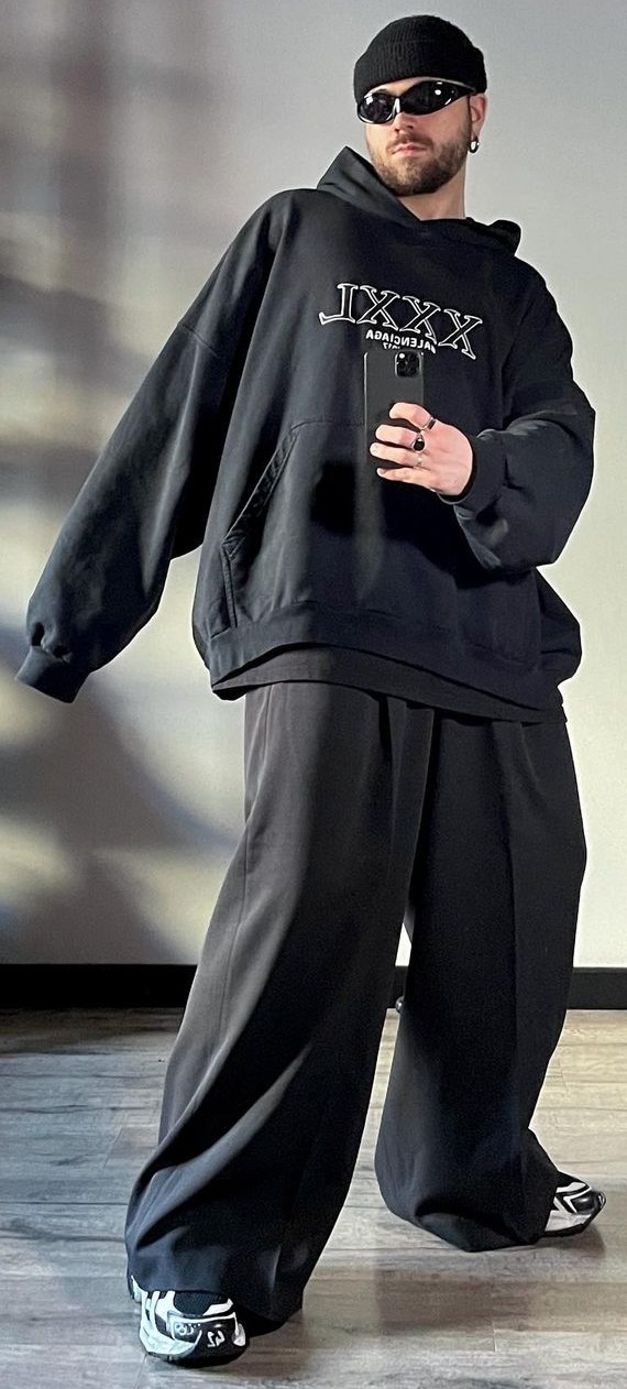 Balenciaga Oversized Hoodies with a baggy bottom accessorized with shades, a cap and rings, completing the look with sneakers being one of the must-have products to own Balenciaga Oversized Hoodies with a baggy bottom accessorized with shades, a cap and rings, completing the look with sneakers being one of the must-have products to own
