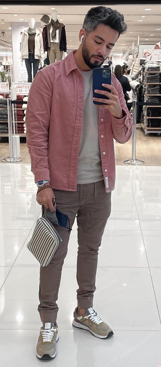 cargo pants in brown color with white tshirt and a pink jacket, accessorized with a bag, watch and air pods that completes the look with brown shoes cargo pants in brown color with white tshirt and a pink jacket, accessorized with a bag, watch and air pods that completes the look with brown shoes