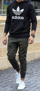 classic cargo pants in green color with black tshirt, accessorized with a watch and white sneakers classic cargo pants in green color with black tshirt, accessorized with a watch and white sneakers