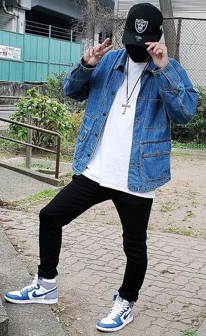 denim jacket with white tshirt and black bottoms, accessorized with the sneaker brand Nike, a cross and a cap denim jacket with white tshirt and black bottoms, accessorized with the sneaker brand Nike, a cross and a cap