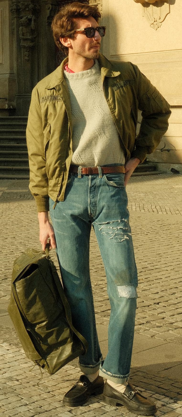 Gucci loafers being a must-have product with ripped denim and cream colored tshirt with a green jacket, accessorized with shades and a bag Gucci loafers being a must-have product with ripped denim and cream colored tshirt with a green jacket, accessorized with shades and a bag